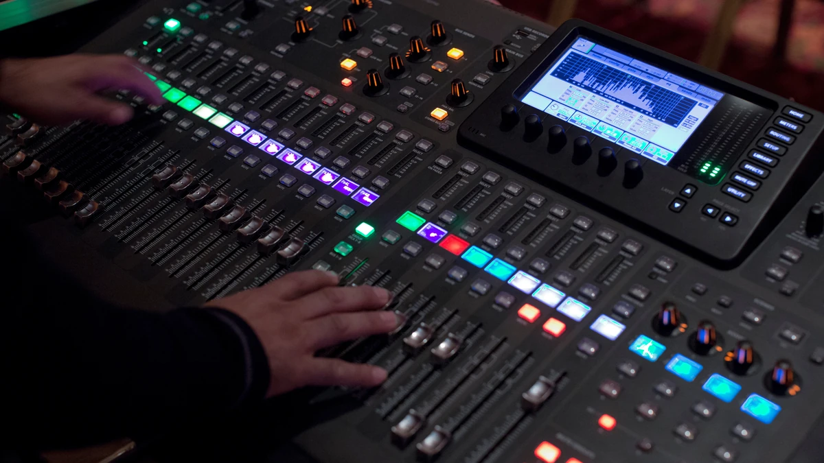 Digital mixing console with a colour screen and rows of lit buttons