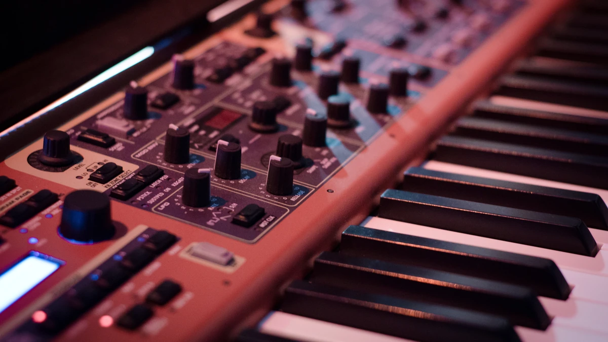 Close view of a red stage keyboard with rows of knobs above the piano keys
