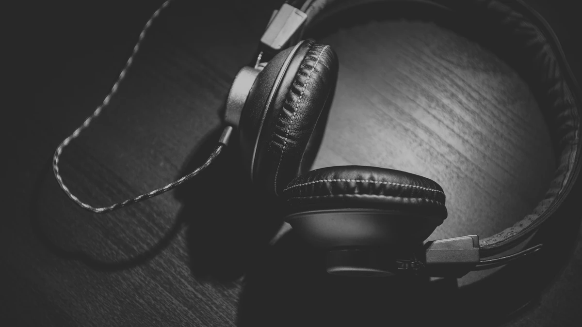 Black over-ear headphones lying on a dark wooden surface