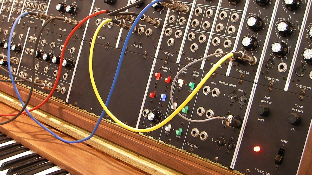 Vintage modular synthesizer with colourful patch cables and a keyboard below